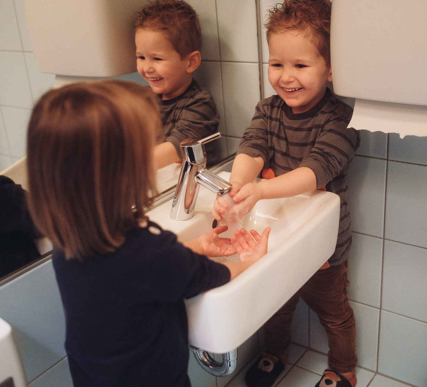 Zwei Kinder waschen sich im Bad der Krippe des Montessori Zentrum Ortenau die Hände